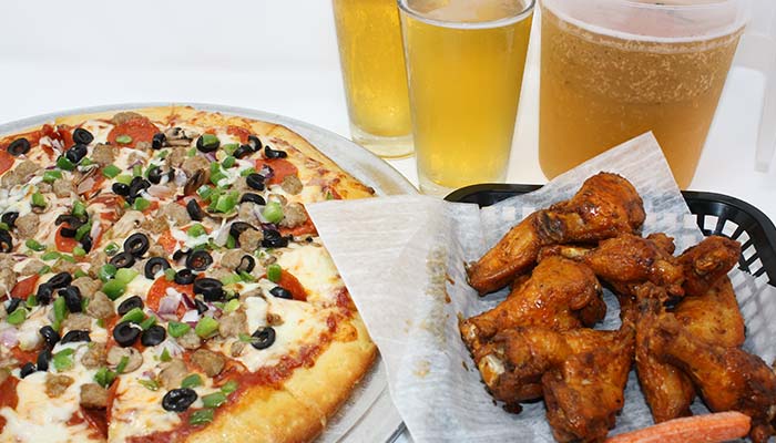 FUBAR Pizza Bar restaurant pizzeria in Fort Walton Beach, Florida waterfront supreme pizza, basket of chicken wings and ice cold tap beer